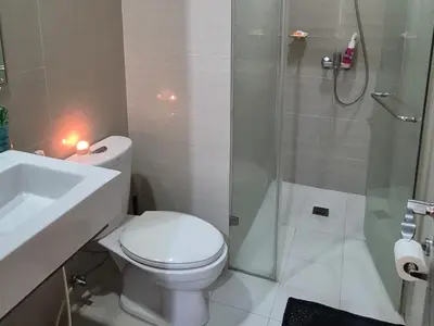 a bathroom with a toilet and a shower and a sink at A&G Condotel at 101newport Near NAIA T3 in Manila