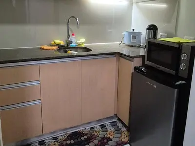 a small kitchen with a sink and a microwave at A&G Condotel at 101newport Near NAIA T3 in Manila