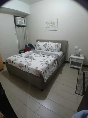 a bedroom with a bed with a flowery comforter at A&G Condotel at 101newport Near NAIA T3 in Manila