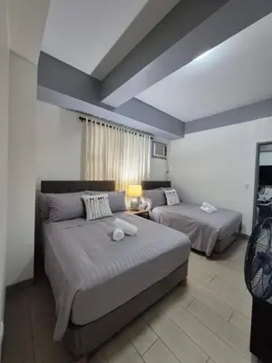 a living room with two beds and a couch at SMT Condo Hotel in Manila
