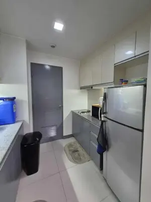 a kitchen with a stainless steel refrigerator and cabinets at SMT Condo Hotel in Manila