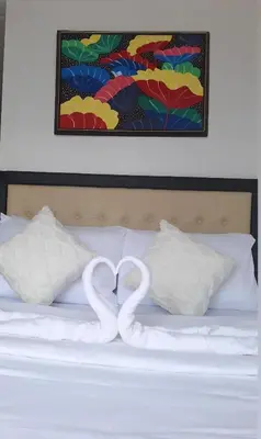 two swans forming a heart on top of a bed at Cozy Staycation in Manila