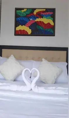 two swans making a heart shape on a bed at Cozy Staycation in Manila