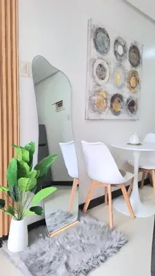 a room with a table and chairs and a mirror at Cozy Staycation in Manila