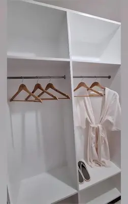 a white closet with hangers and shoes in it at Cozy Staycation in Manila