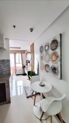 a living room with a table and chairs and a fireplace at Cozy Staycation in Manila