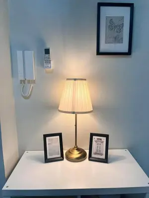 a lamp on a table with two pictures on it at Sofia's place shore 3 tower 2 in Manila