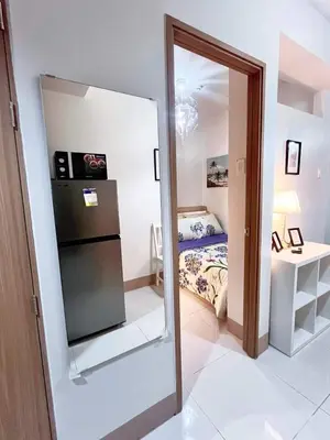 a mirror in a small room with a bedroom at Sofia's place shore 3 tower 2 in Manila