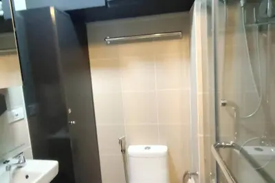 a bathroom with a toilet and a glass shower at Condo With Water Views in Manila
