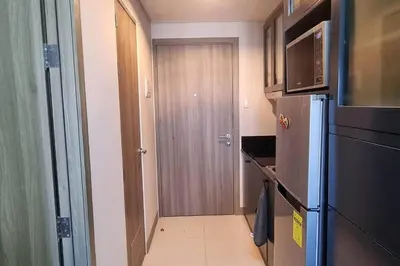a small kitchen with a refrigerator and a door at Condo With Water Views in Manila