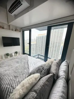 a bedroom with a large bed and a large window at Air Residences Suite by Christine Suites PH in Manila