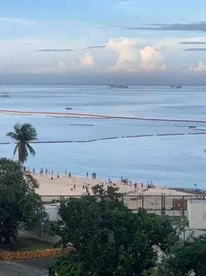 a group of people on a beach near the water at US Embassy, Cozy Condo, Ermita, Manila Roxas Blvd in Manila