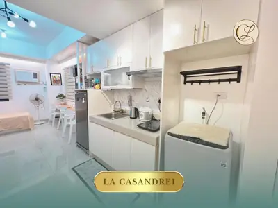 a kitchen with white cabinets and a refrigerator at La Casandrei in San Agustin