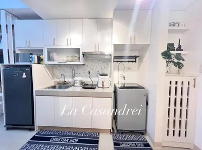 a kitchen with white cabinets and a black refrigerator at La Casandrei in San Agustin