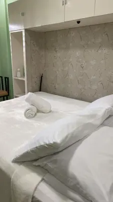 a white bed with two pillows on top of it at FACE Transient Rooms in Kawit