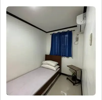 a small bed in a room with a blue curtain at Florie's Home in Santa Rosa