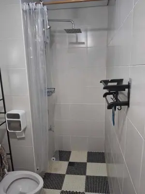 a bathroom with a shower and a toilet in it at Affordable Stay near BGC, Makati in Manila