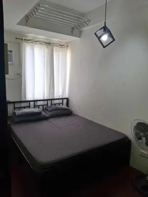 a bedroom with a bed in a room with a window at Affordable Stay near BGC, Makati in Manila