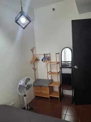 a room with a fan and a shelf and a fan at Affordable Stay near BGC, Makati in Manila