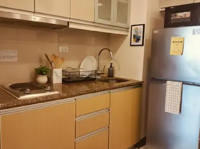a kitchen with a stainless steel refrigerator and a sink at BGC McKinley Apartment B1 in Manila