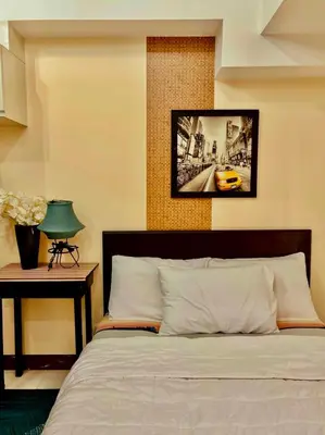 a bedroom with a bed and a picture on the wall at BGC McKinley Apartment B1 in Manila