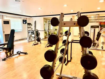 a gym with several treadmills and weights at Cozy Home in BGC McKinley B2 in Manila