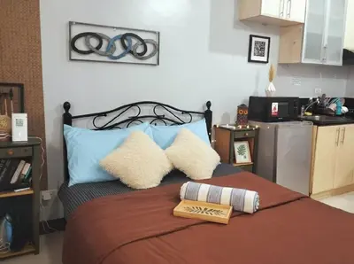 a bedroom with a bed with two pillows on it at Heart of BGC McKinley B3 in Manila