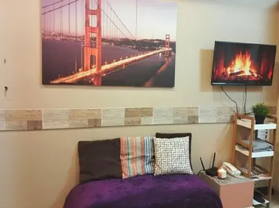 a bedroom with a purple bed and a bridge painting on the wall at Heart of BGC McKinley B3 in Manila