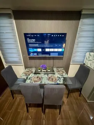 a dining room table with chairs and a television at Air Residences 43rdF -By Soliel in Manila
