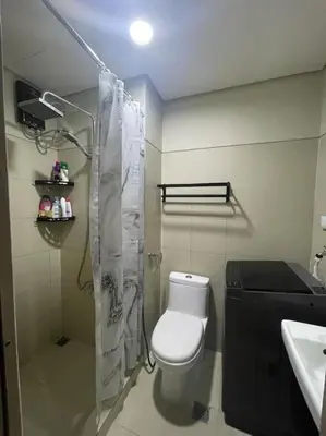 a bathroom with a toilet and a shower and a sink at Juliš Apartment S residence- Moa complex pasay in Manila