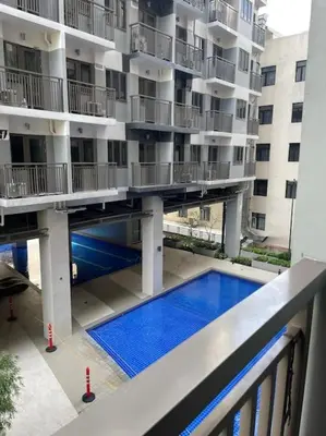 an apartment building with a swimming pool in front of it at Juliš Apartment S residence- Moa complex pasay in Manila