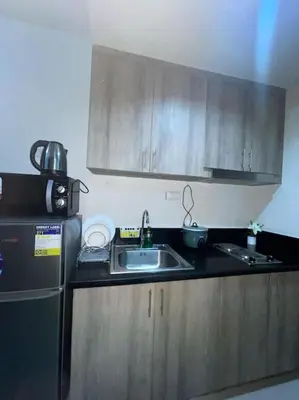 a small kitchen with a sink and a refrigerator at Juliš Apartment S residence- Moa complex pasay in Manila