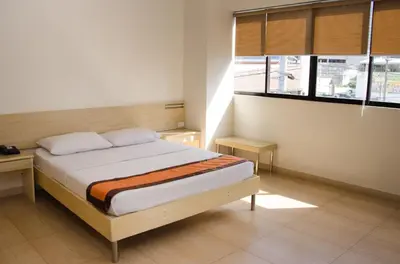 a bedroom with a bed and two windows at M Suites Hotel in Manila