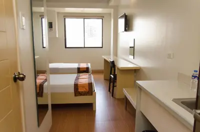 a small room with two bunk beds and a sink at M Suites Hotel in Manila