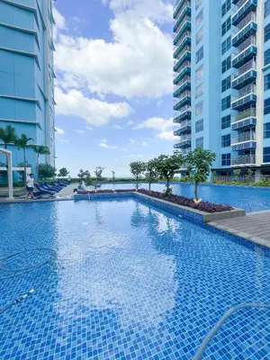 a swimming pool in the middle of two tall buildings at Luxurious 3BR in Manila Bay beside Okada in Manila
