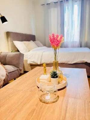 a table with a vase of flowers on top of it at Fair bears accommodation in Manila