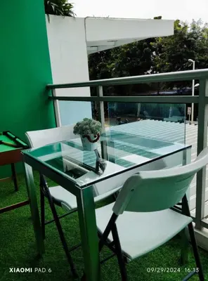 a glass table and a chair on a balcony at 225 St Tropez Tower Azure Urban Resort Residences in Manila