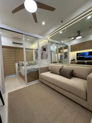 a living room with a couch and a bedroom at Antoneitte Staycation in Manila