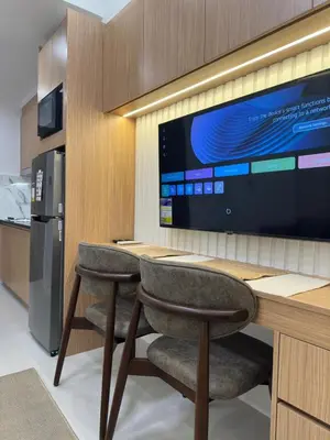 a kitchen with a desk with two chairs and a refrigerator at Antoneitte Staycation in Manila