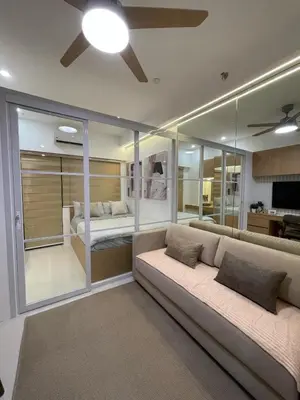 a living room with a couch and a bedroom at Antoneitte Staycation in Manila