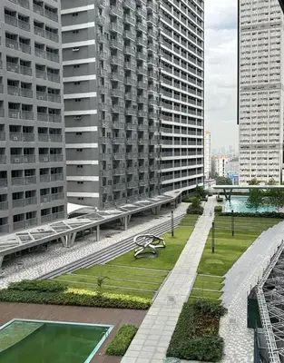 a bench in the middle of a city with tall buildings at Antoneitte Staycation in Manila