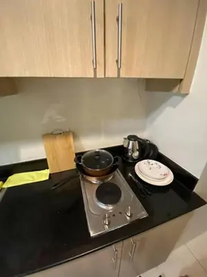 a kitchen counter with a stove with a pot on it at Breeze Residences 26th floor in Manila