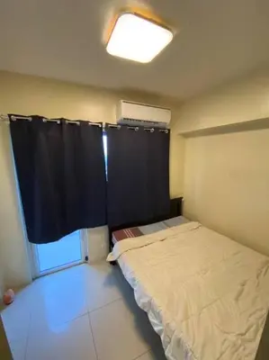 a small bedroom with a bed and a window at Breeze Residences 26th floor in Manila