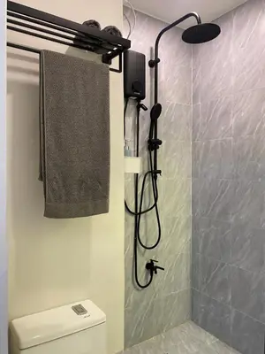 a bathroom with a shower with a toilet and a towel at La Casa Benice in Manila