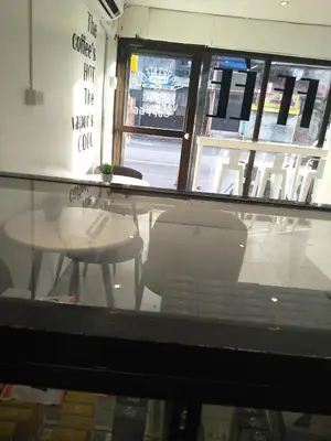 a glass table and chairs in a restaurant with a window at Brokeside in Cainta