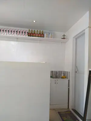 a kitchen with white walls and a white refrigerator at Brokeside in Cainta