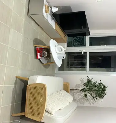 a living room with a chair and a television at The Roch in Manila
