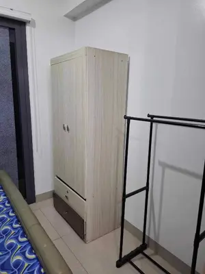 a bedroom with a wooden cabinet next to a bed at Shore2 Residences in Manila
