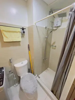 a bathroom with a shower and a toilet with a rug at Casa Reyes in Manila