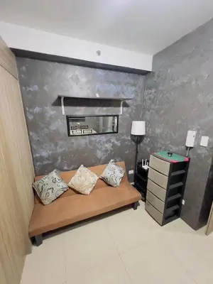 a room with a couch and a dresser with a mirror at Casa Reyes in Manila